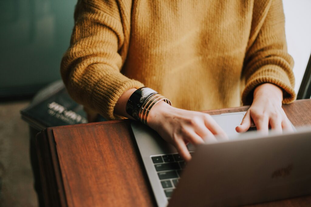 Hands of a woman confidently typing on her laptop.